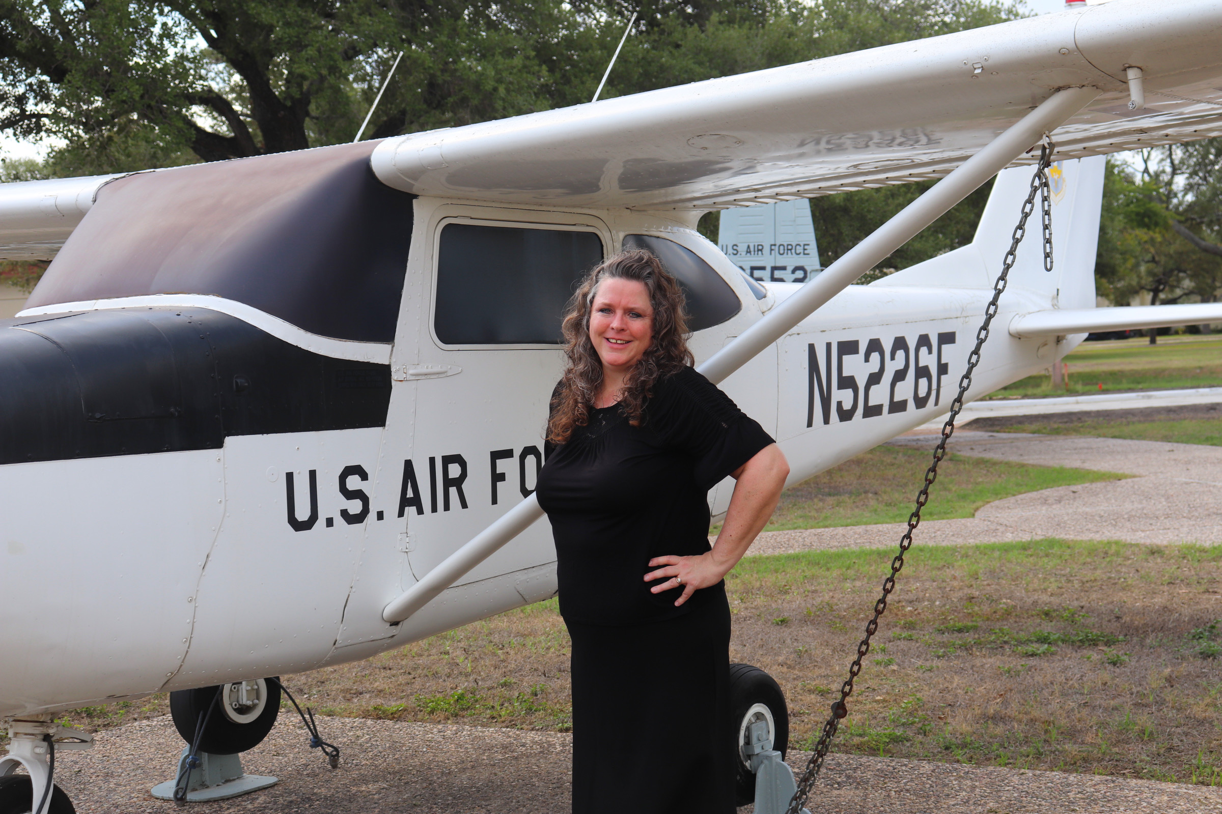 Image of Barbi standing in front of a plane